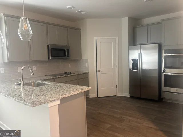 a kitchen with stainless steel appliances granite countertop a kitchen island a refrigerator sink and microwave