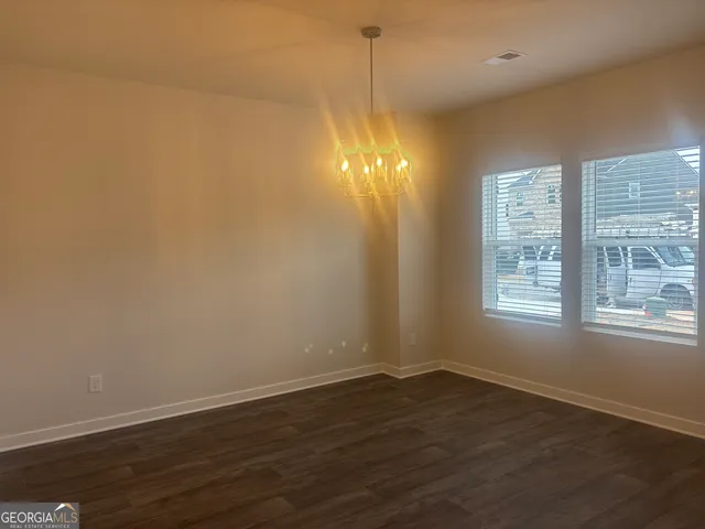 a view of a room with wooden floor and windows