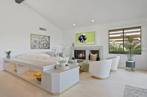 a living room with furniture large window and a fireplace