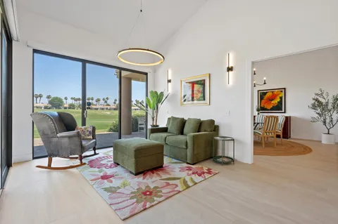 a living room with furniture and a floor to ceiling window