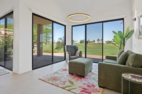 a living room with furniture and a floor to ceiling window