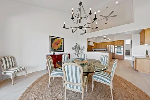 a view of a dining room with furniture a chandelier and wooden floor