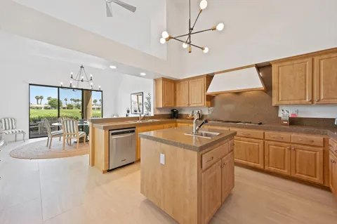 a kitchen with granite countertop a sink appliances cabinets and furniture