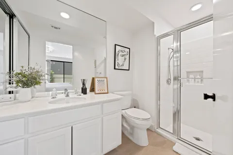 a bathroom with a granite countertop sink a toilet and mirror