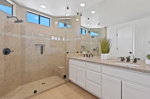 a bedroom with a bed a couch and a chandelier