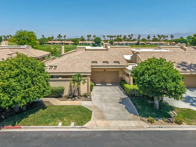 an aerial view of a house with a yard and lake view