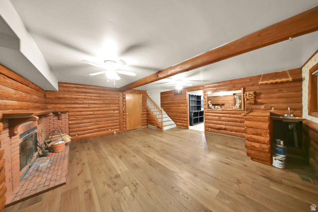374 West Lakeview Road Lindon, UT 84042 - Photo 36 of 44 Spacious room featuring log-style walls, wood-finish flooring, a brick fireplace, exposed wood ceiling beams, and a built-in wet bar