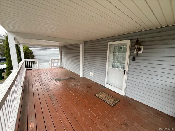 a view of a deck with wooden floor and floor to ceiling window