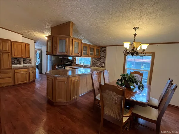 a dining room with furniture a chandelier and wooden floor