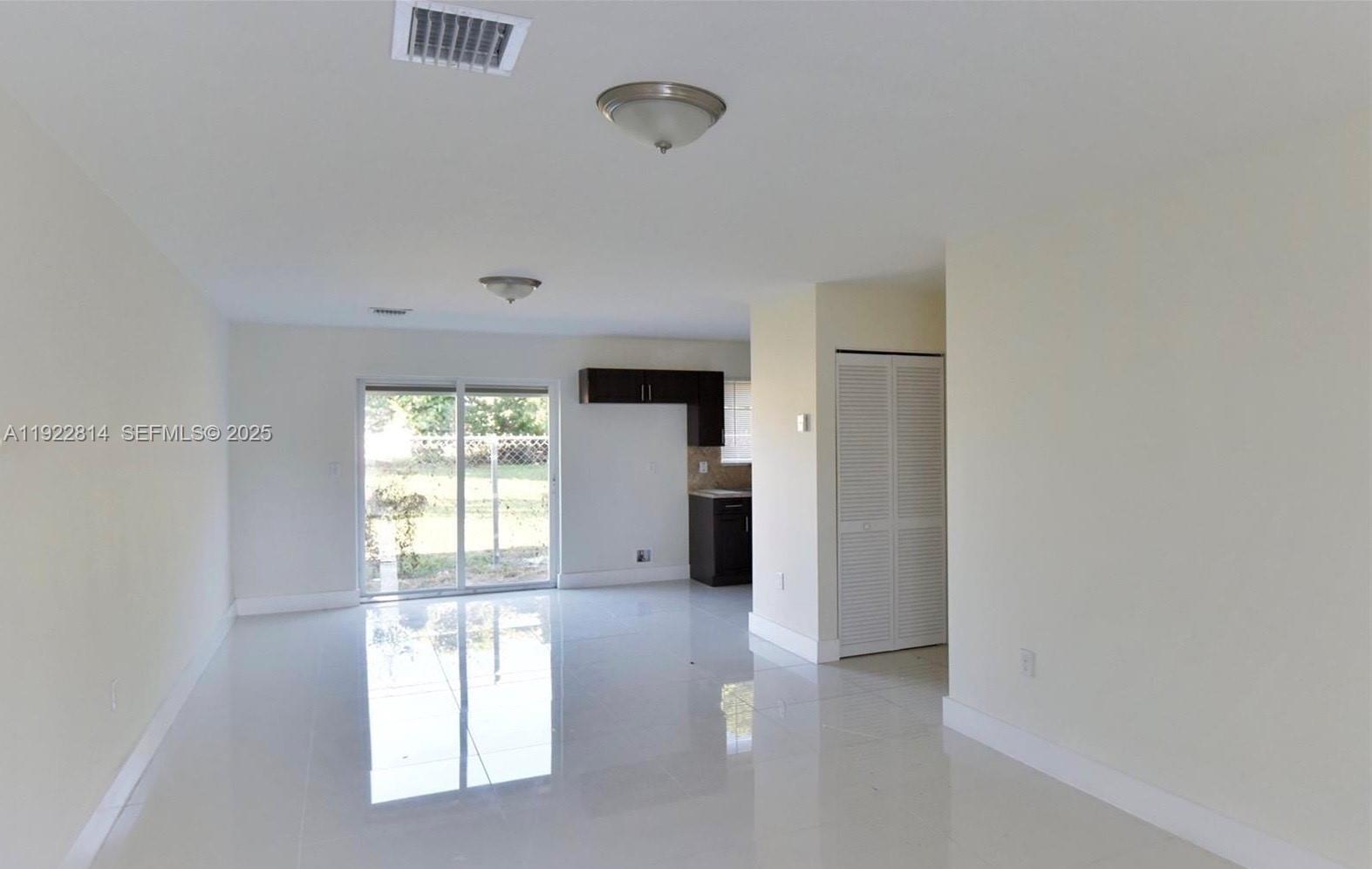 1980 Northwest 54th Street, Unit A Miami, FL 33142 - Photo 2 of 9 a view of an empty room with a window
