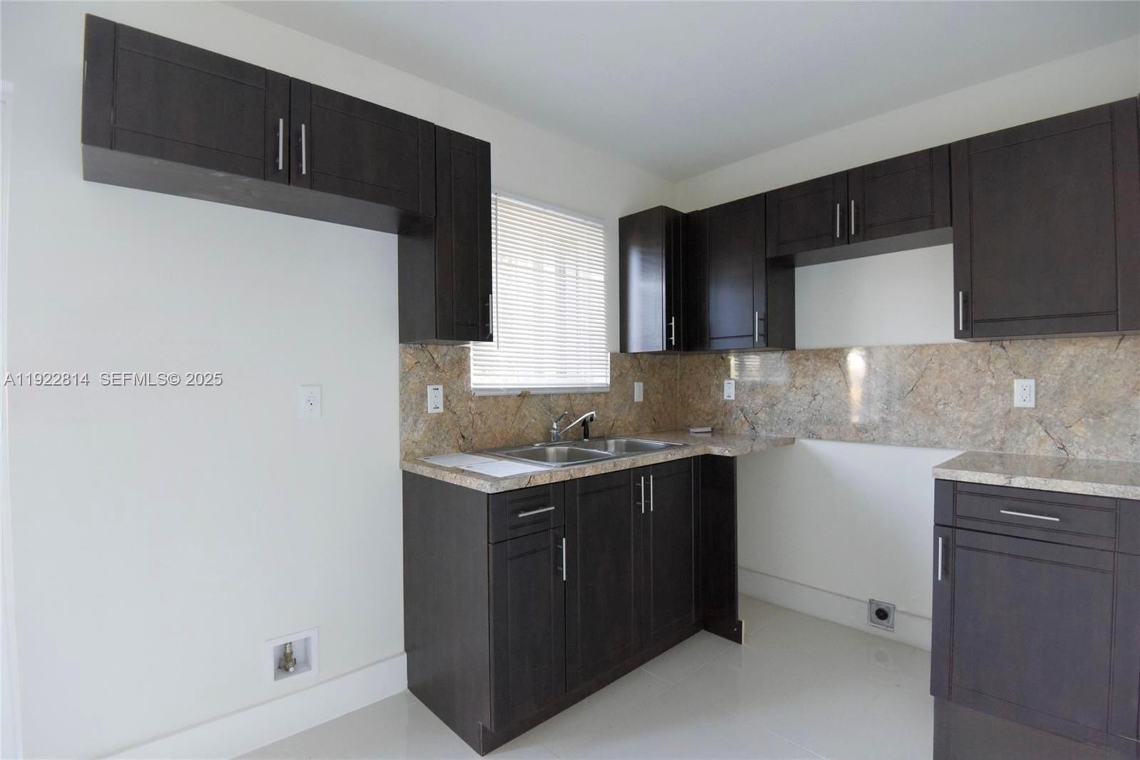 1980 Northwest 54th Street, Unit A Miami, FL 33142 - Photo 4 of 9 a kitchen with a sink and cabinets