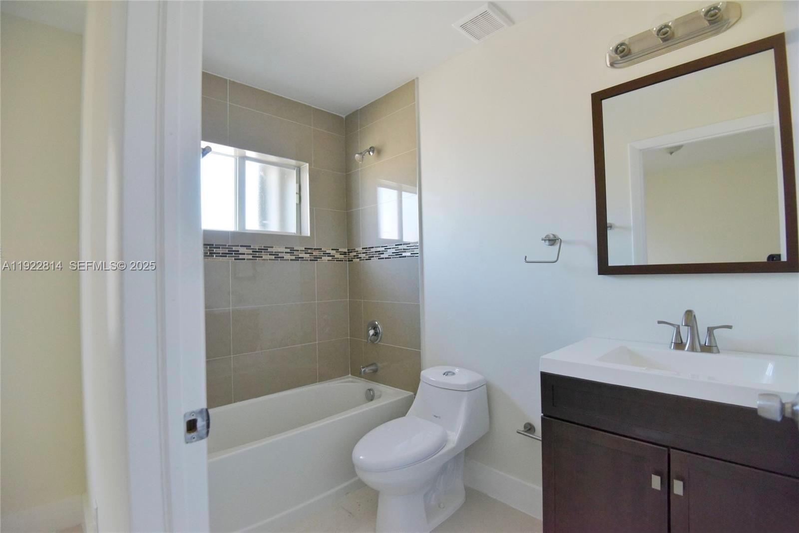 1980 Northwest 54th Street, Unit A Miami, FL 33142 - Photo 6 of 9 a bathroom with a toilet a sink and bathtub