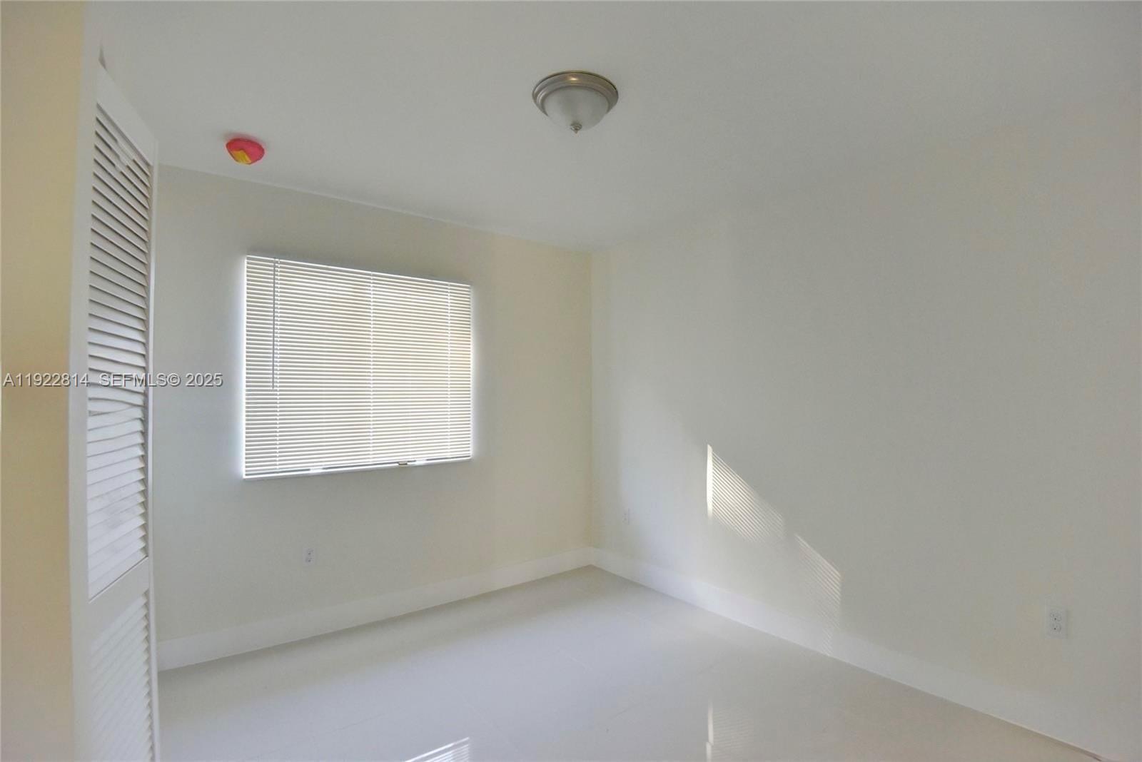 1980 Northwest 54th Street, Unit A Miami, FL 33142 - Photo 7 of 9 a view of an empty room with a window