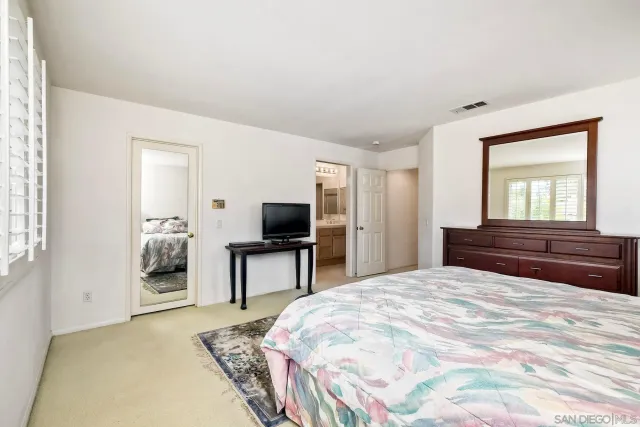 a bathroom with a granite countertop sink a toilet and a mirror