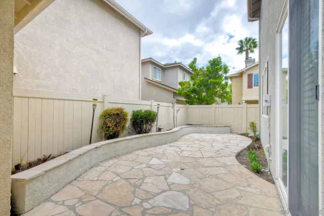 a view of a house with a yard and potted plants