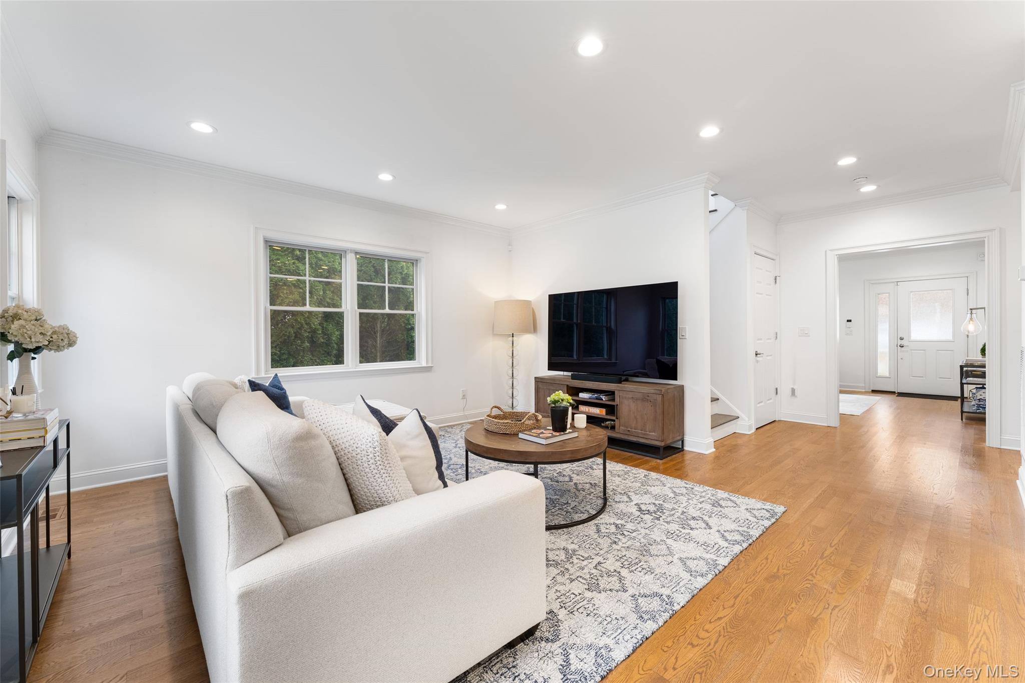 109 Lee Road Scarsdale, NY 10583 - Photo 11 of 33 Living room featuring crown molding, light wood-style flooring, recessed lighting, and stairs