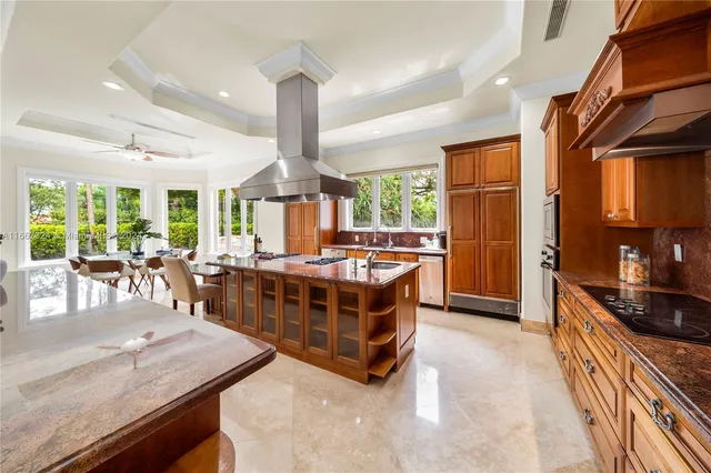 a large kitchen with kitchen island a large counter top space a sink stainless steel appliances and cabinets