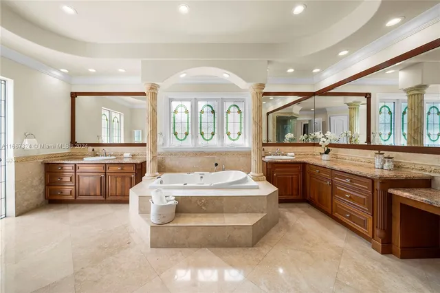 a en suite bathroom with a granite countertop tub and a large window