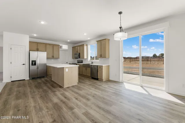 a large kitchen with cabinets and a wooden floor