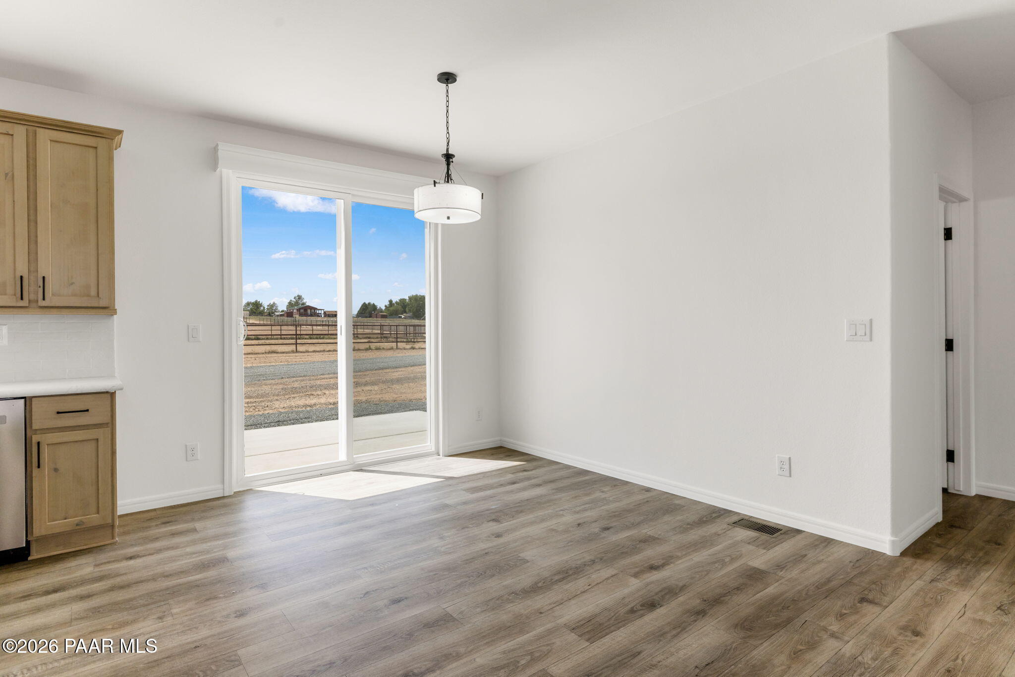 9905 East Ringold Road Dewey-Humboldt, AZ 86327 - Photo 9 of 20 a view of an empty room with a window and wooden floor