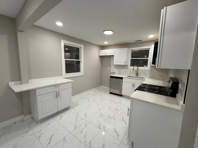a kitchen with white cabinets and sink