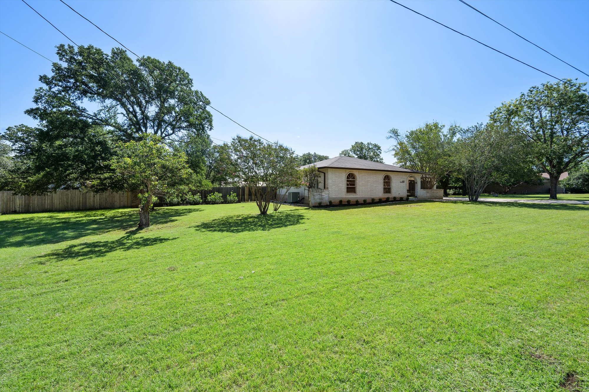 109 Woodland Road Georgetown, TX 78628 - Photo 4 of 40 A sprawling green lawn surrounds this classic brick residence, offering ample outdoor living space.