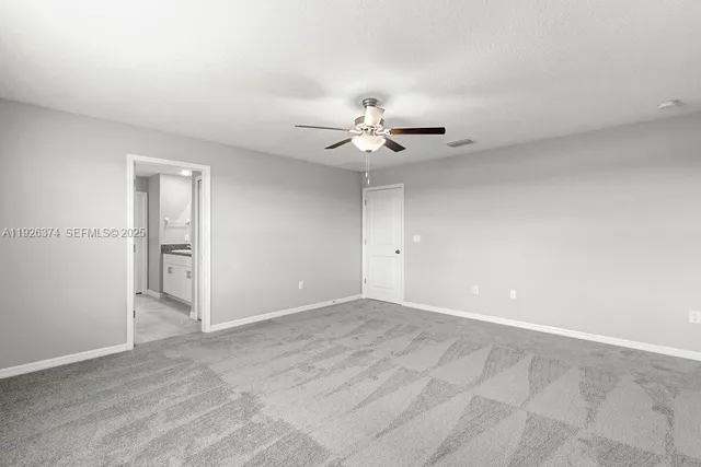 a view of an empty room with a ceiling fan
