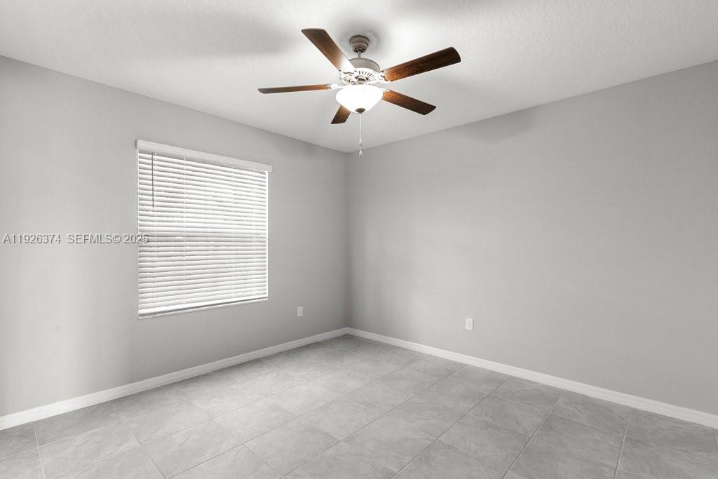 5351 Night Tide Lane Wimauma, FL 33598 - Photo 21 of 22 an empty room with ceiling fan and window