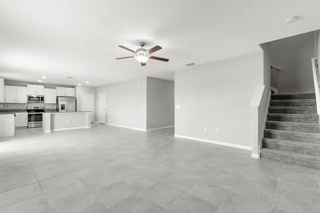 a view of a kitchen with wooden cabinet and a kitchen space with a sink