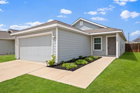 a front view of a house with a garden and plants