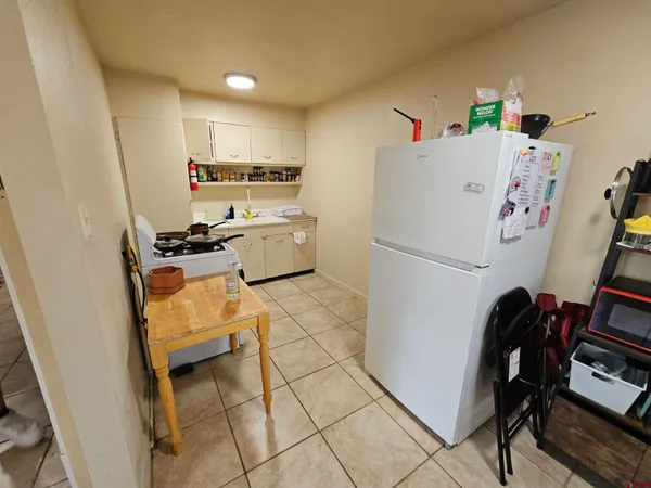a kitchen with a refrigerator and a stove top oven