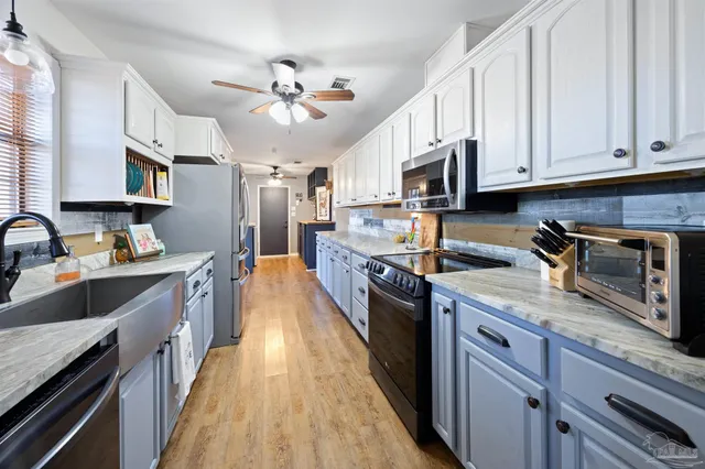 a kitchen with stainless steel appliances granite countertop a stove a sink and a microwave