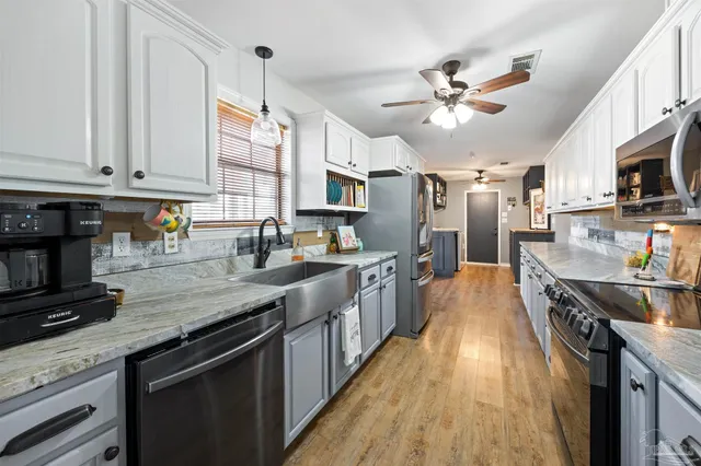 a kitchen with stainless steel appliances granite countertop a lot of counter space and wooden floor