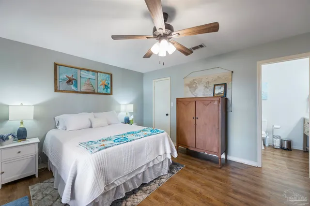 a bedroom with a bed and a flat tv screen on dresser