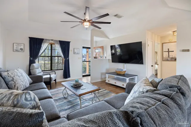 a living room with furniture a flat screen tv and a fireplace