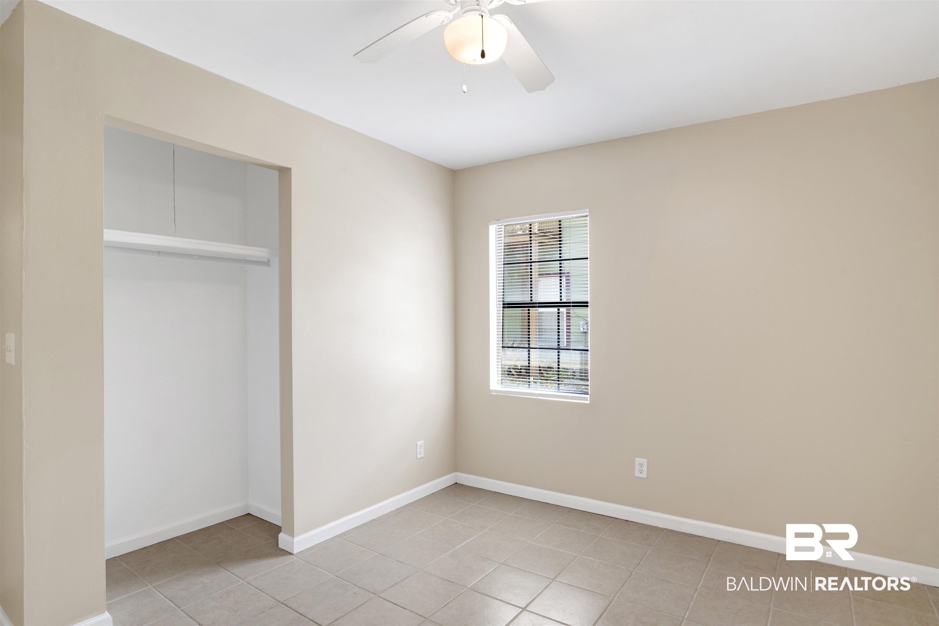 7411 Bay Road Mobile, AL 36605 - Photo 9 of 34 Unfurnished bedroom featuring a closet, light tile patterned floors, and a ceiling fan