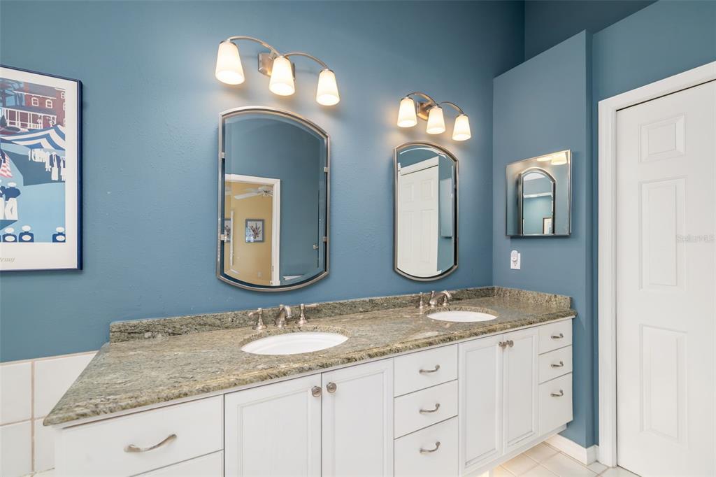 4480 Ascot Circle South Sarasota, FL 34235 - Photo 21 of 76 a bathroom with double vanity sinks and a mirror