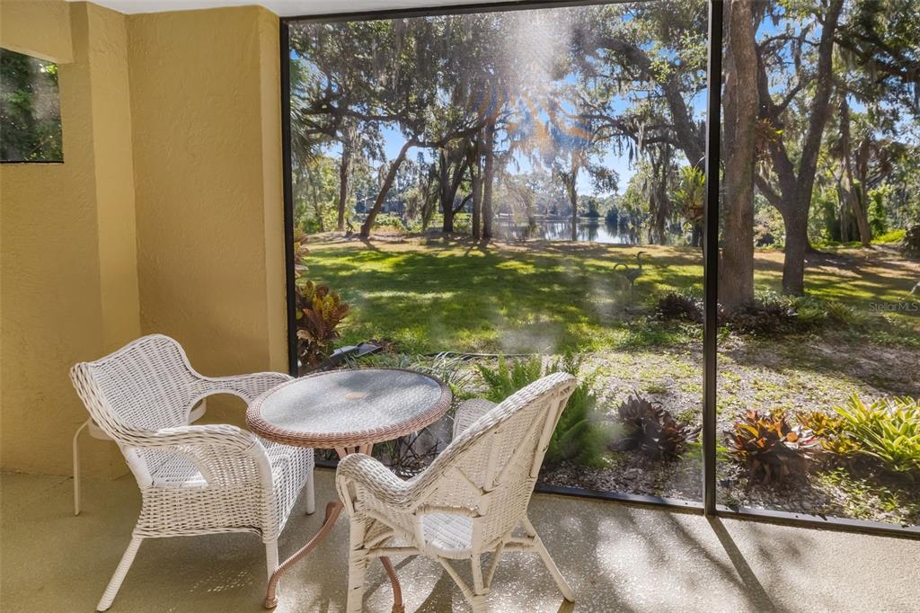4480 Ascot Circle South Sarasota, FL 34235 - Photo 38 of 76 a view of a patio with table and chairs and floor to ceiling window