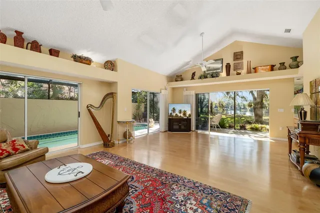 a living room with furniture and a dining table with wooden floor