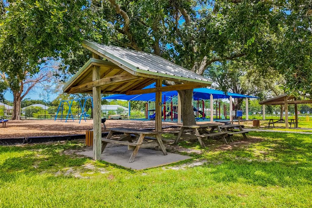 4480 Ascot Circle South Sarasota, FL 34235 - Photo 74 of 76 a backyard of a house with barbeque oven table and chairs