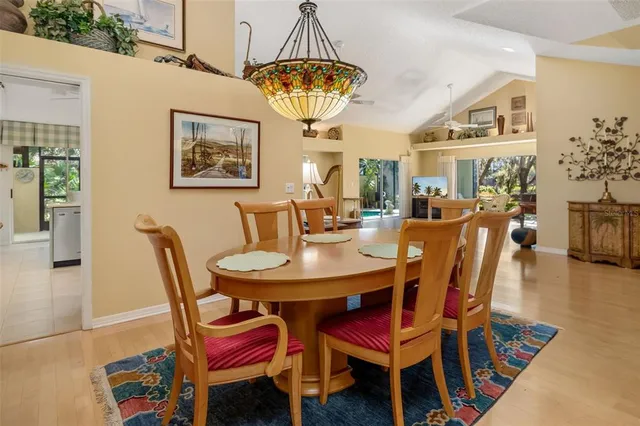 a dining room with furniture a chandelier and wooden floor
