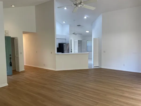 a view of a kitchen with kitchen island wooden floor and ceiling fan
