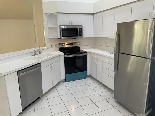 a kitchen with a refrigerator sink and cabinets