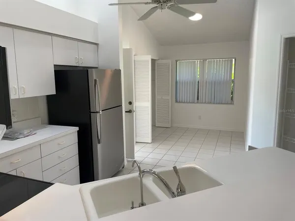 a kitchen with a refrigerator sink and cabinets