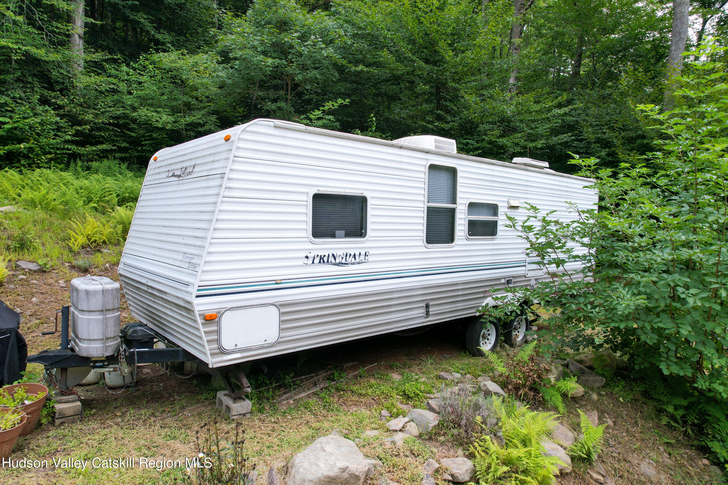 208 Pantherkill Road Phoenicia, NY 12464 - Photo 14 of 16 a view of a backyard with a chair and potted plants