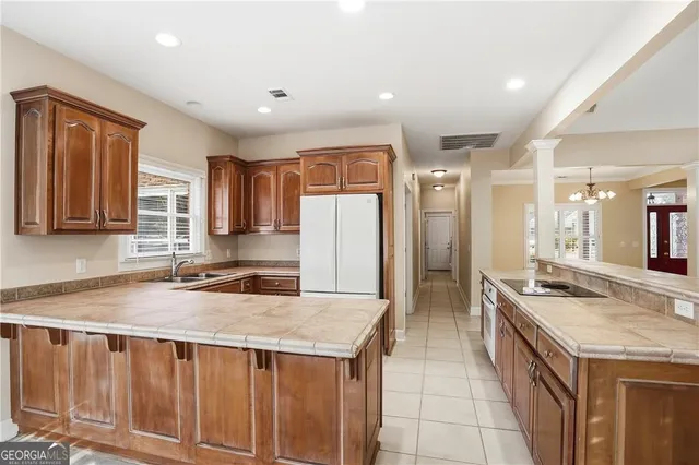 a kitchen with granite countertop a sink a counter top space stainless steel appliances cabinets and a counter top space