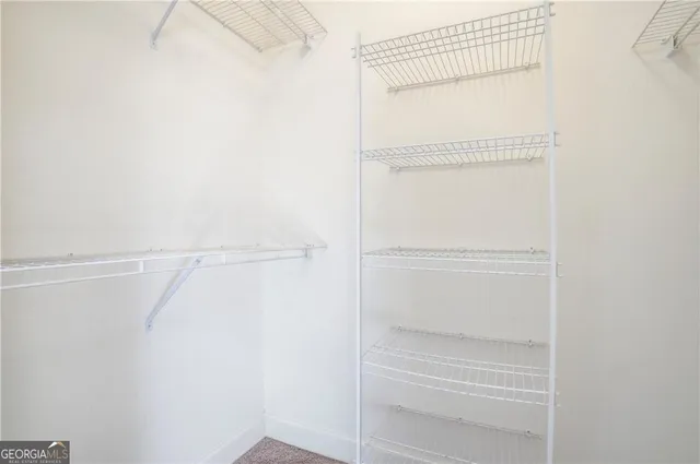 a view of walk in closet with empty racks