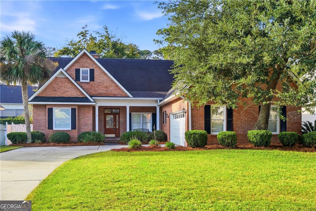 171 West Commons Drive St. Simons, GA 31522 - Photo 2 of 39 a front view of a house with garden