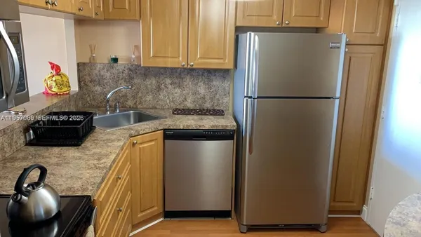 a kitchen with stainless steel appliances granite countertop a refrigerator and a sink