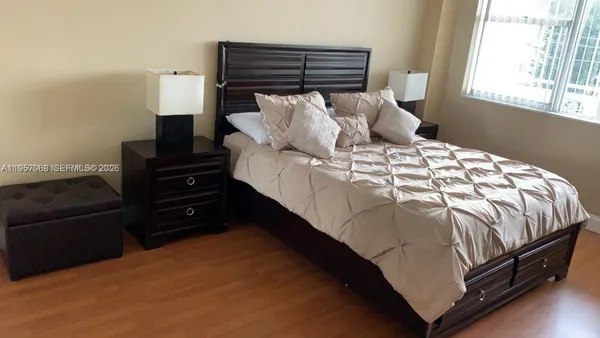 a bed sitting in a bedroom next to a window